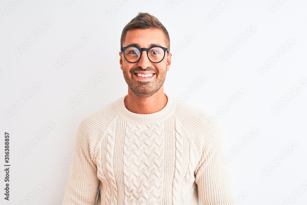 Young handsome man wearing glasses and winter sweater over isolated background with a happy face standing and smiling with a confident smile showing teeth Young handsome man wearing glasses and winter sweater over isolated background with a happy face standing and smiling with a confident smile showing teeth