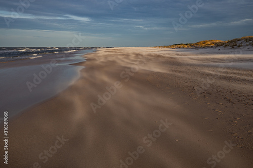 Obraz na płótnie A beach after a storm during a windy evening in the Slowinski National Park. Czolpino, Leba, Poland. w salonie