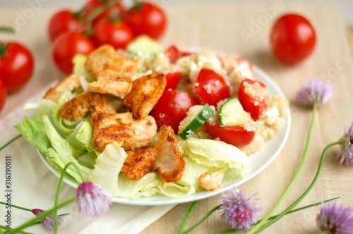 Quinoa salad with chicken fillets, lettuce, tomato, cucumber and chives