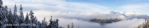 Whistler, British Columbia, Canada. Beautiful Panoramic View of the Canadian Snow Covered Mountain Landscape during a cloudy and foggy winter day. © edb3_16