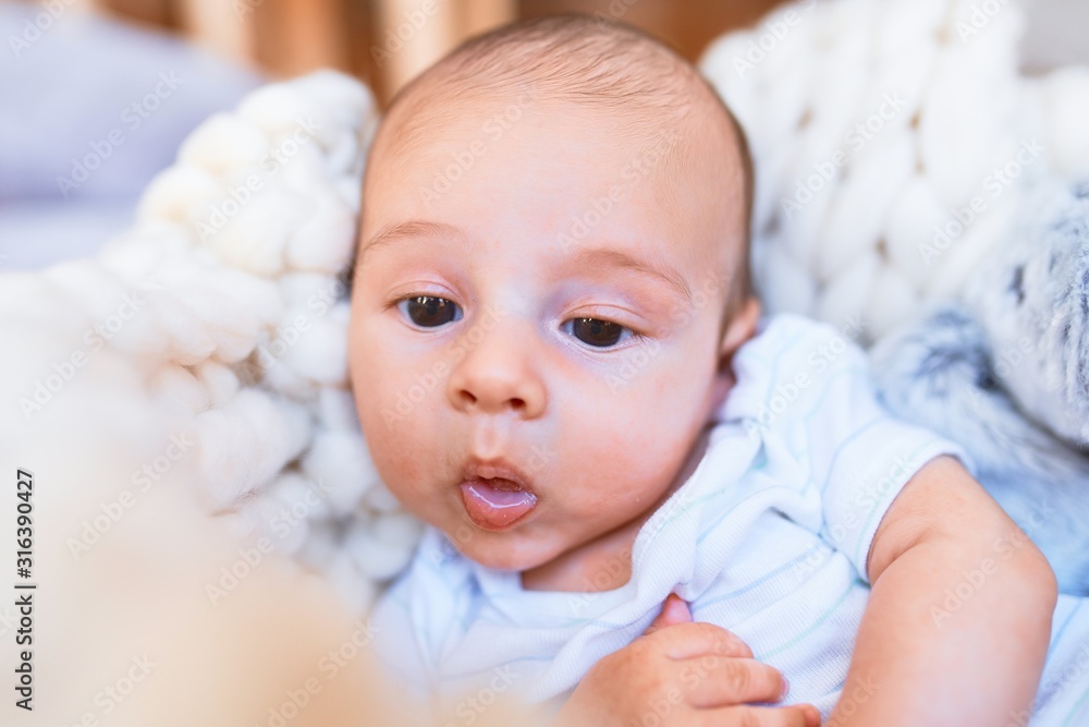 Adorable baby lying down over blanket on the floor at home. Newborn relaxing and resting comfortable Adorable baby lying down over blanket on the floor at home. Newborn relaxing and resting comfortable