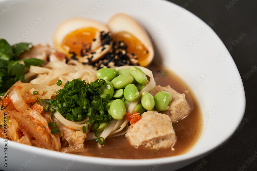 Asian noodles soup, ramen with chicken, tofu, vegetables and egg, close-up Asian noodles soup, ramen with chicken, tofu, vegetables and egg, close-up