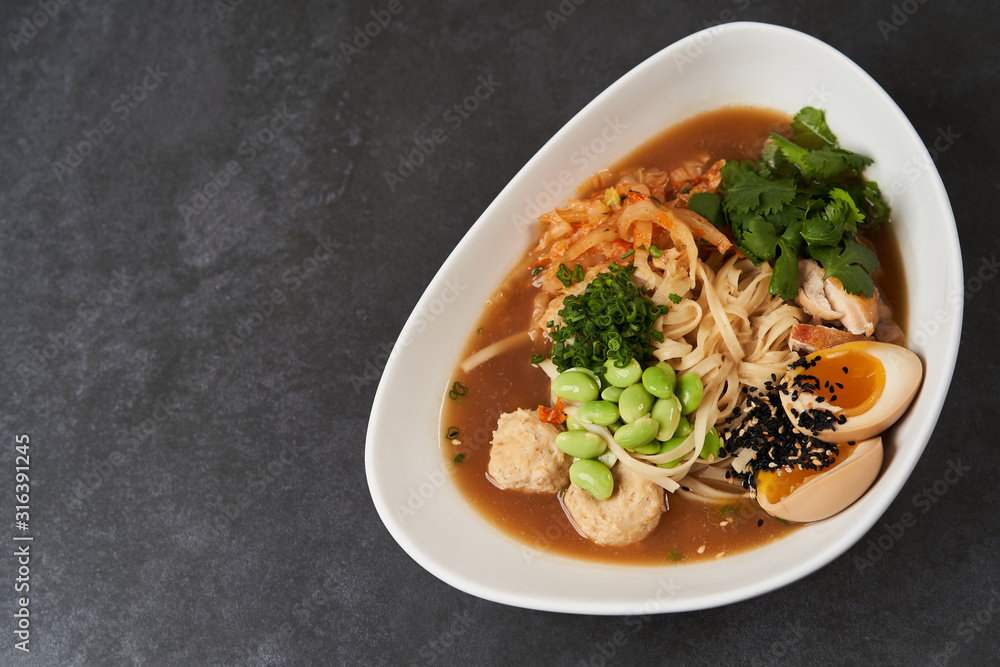 Asian noodles soup, ramen with chicken, tofu, vegetables and egg, close-up Asian noodles soup, ramen with chicken, tofu, vegetables and egg, close-up