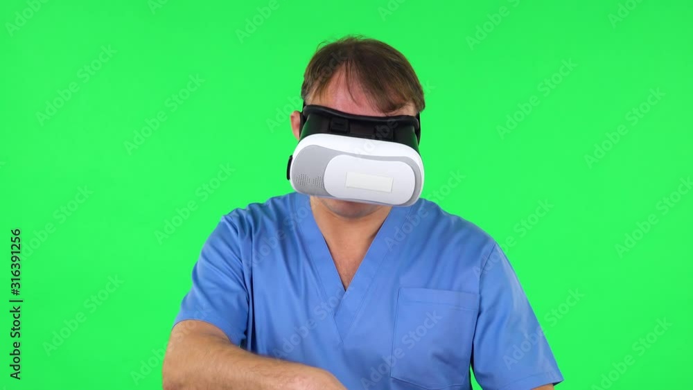 Surgeon makes a virtual operation with 3D glasses. Green screen Surgeon makes a virtual operation with 3D glasses. Green screen