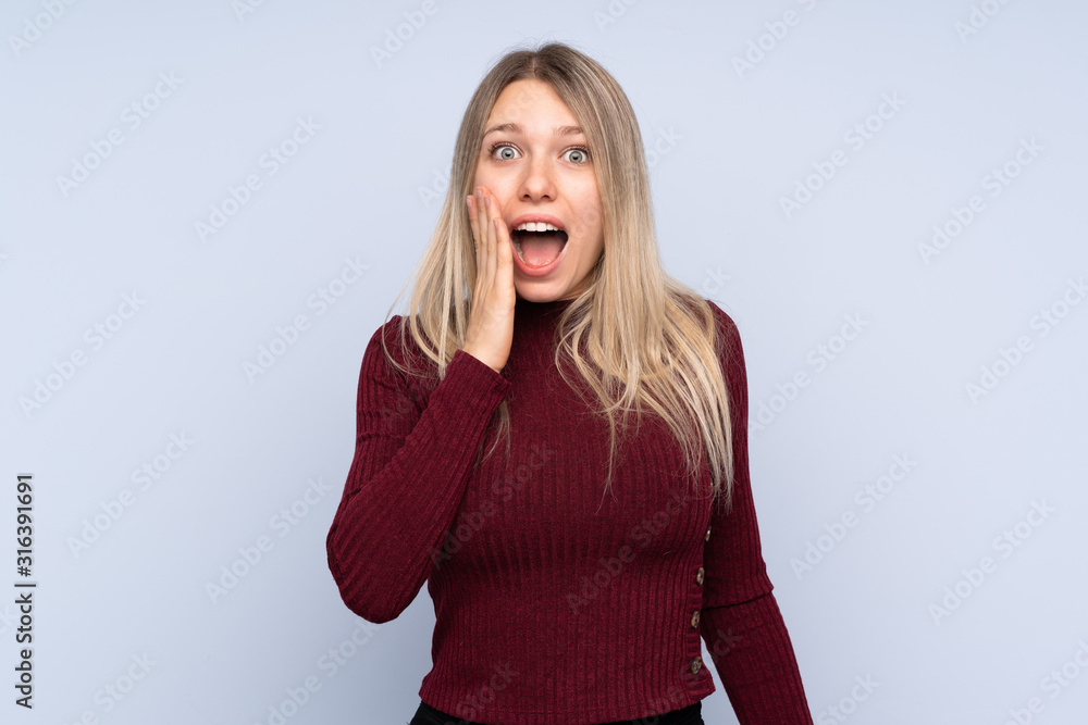 Young blonde woman over isolated blue background with surprise and shocked facial expression Young blonde woman over isolated blue background with surprise and shocked facial expression