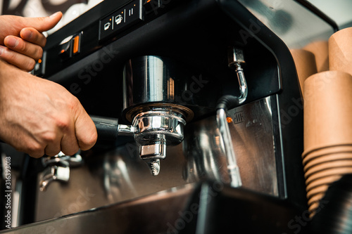 Barista hand holding filter and pressing coffee to making an espresso