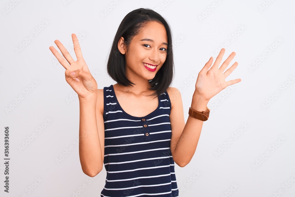 Young chinese woman wearing striped t-shirt standing over isolated white background showing and pointing up with fingers number eight while smiling confident and happy. Young chinese woman wearing striped t-shirt standing over isolated white background showing and pointing up with fingers number eight while smiling confident and happy.