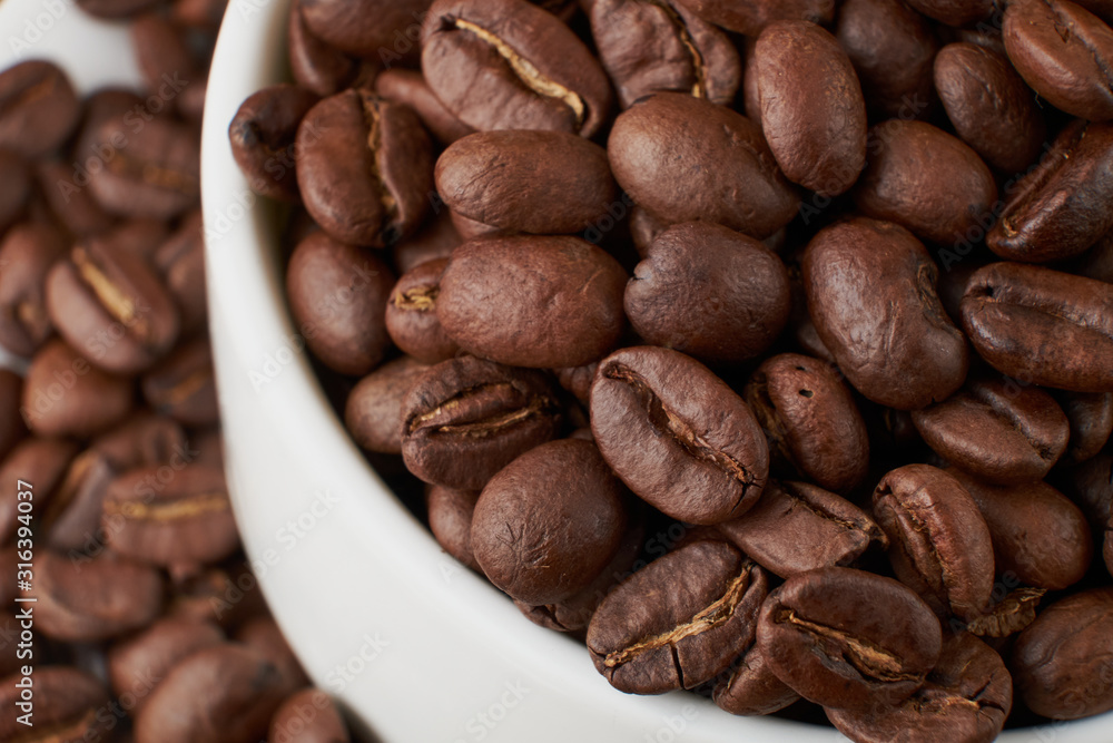 Naklejka premium Filiżanka kawy i ziarna kawy na stole z bliska