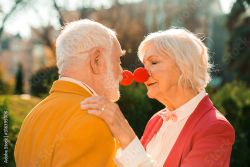 Elderly couple closing their eyes and standing next to each other