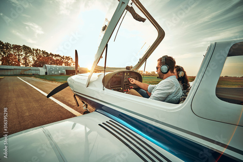 Pilot with co-pilot prepare take off in a small aircraft photo