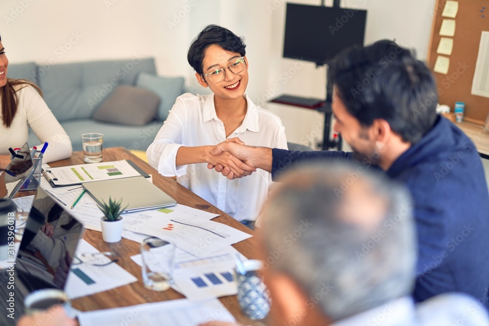 Group of business workers smiling happy and confident. Working together with smile on face shaking hands at the office