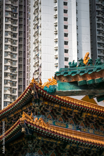 Traditional Chinese architecture in Wong Tai Sin Temple with modern skyscraper background in Hong Kong