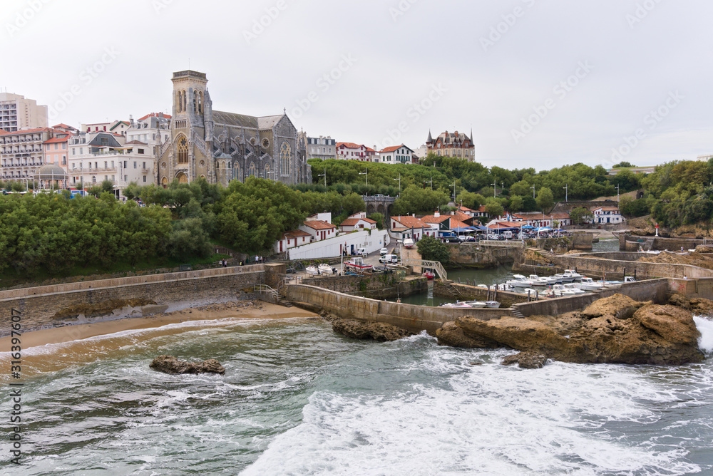 View on the fishing harbour with the cathedral in the background in Biarritz, France