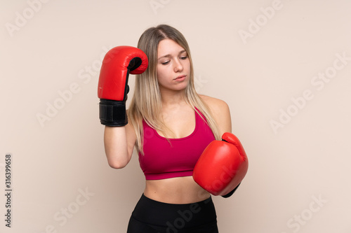 Young sport blonde woman over isolated background with boxing gloves