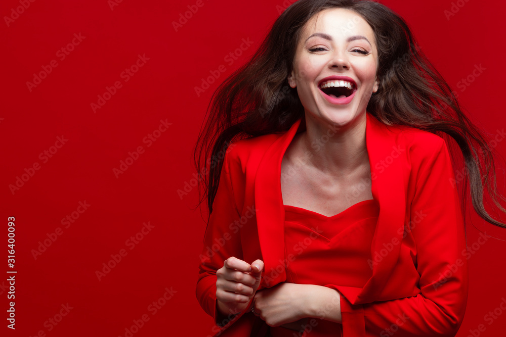 laughing and beautiful girl in a red pantsuit on a red background laughing and beautiful girl in a red pantsuit on a red background