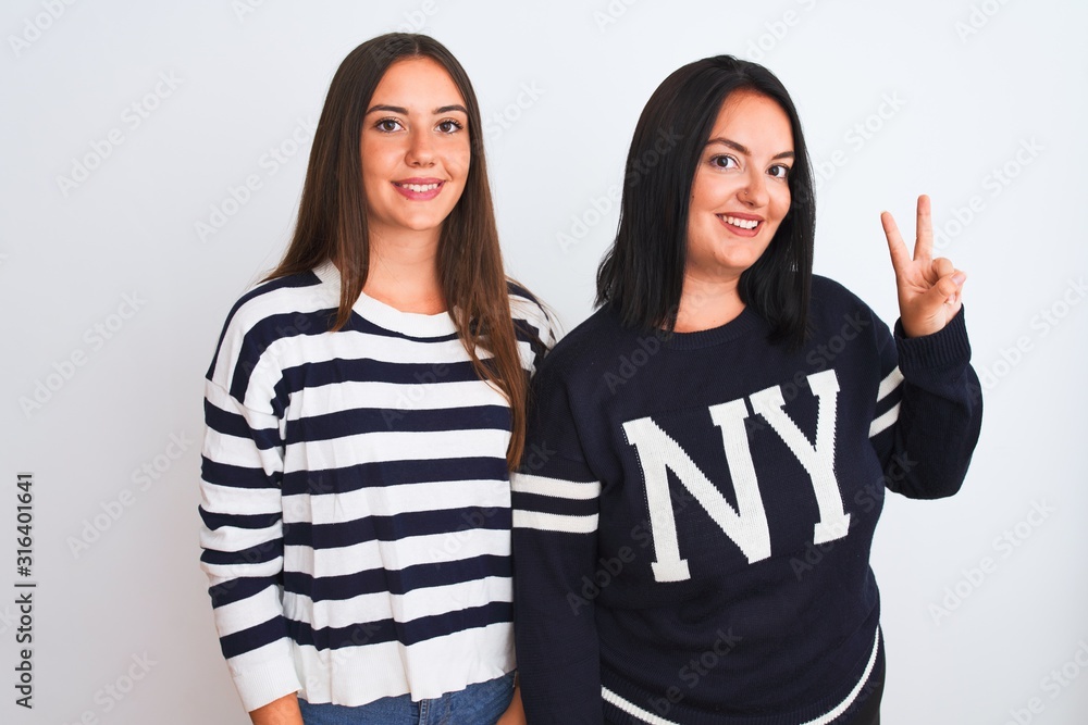 Young beautiful women wearing casual clothes standing over isolated white background showing and pointing up with fingers number two while smiling confident and happy. Young beautiful women wearing casual clothes standing over isolated white background showing and pointing up with fingers number two while smiling confident and happy.
