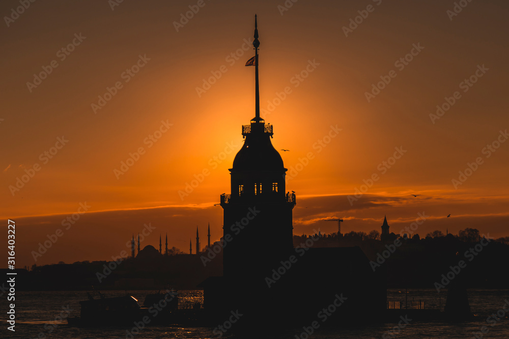 Silhouette of Maiden Tower and Istanbul during sunset golden hour