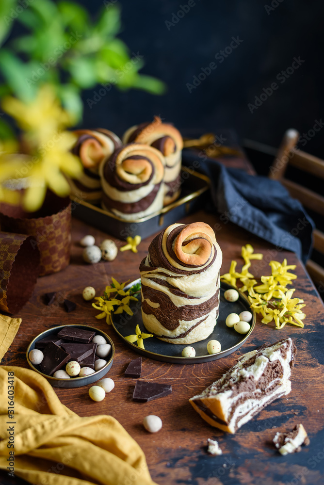 Easter chocolate cake cruffin on wooden table. Homemade Orthodox pastries.  Sliced piece of cake. Easter bread Kulich. Selective focus