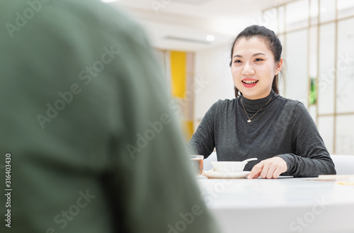 Young asian woman talking face to face in restaurant photo