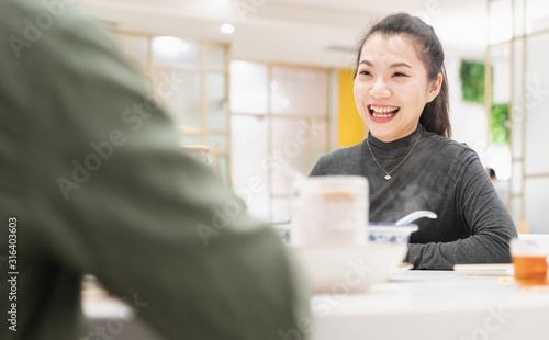 Young asian woman talking face to face in restaurant photo