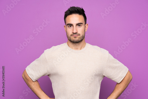 Young handsome man over isolated purple background angry