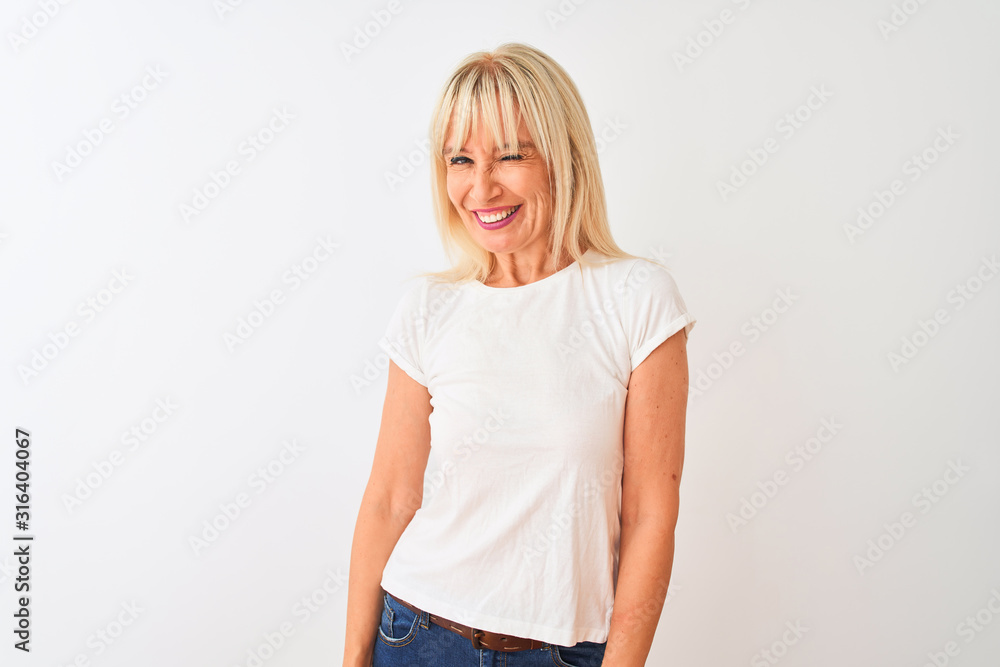 Middle age woman wearing casual t-shirt standing over isolated white background winking looking at the camera with sexy expression, cheerful and happy face. Middle age woman wearing casual t-shirt standing over isolated white background winking looking at the camera with sexy expression, cheerful and happy face.