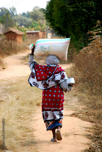 African woman with a sack of flour on his head - Pomerini - Tanzania - Africa photo