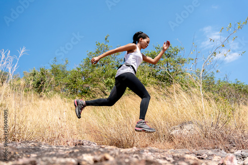 Young Black Woman Running and Jumping at Forest Trail.
