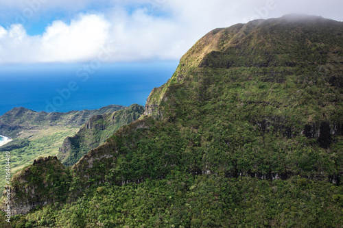 Aerial view of Kauai's lush colorful interior mountain landscape. The southern coast can be seen in the background. 