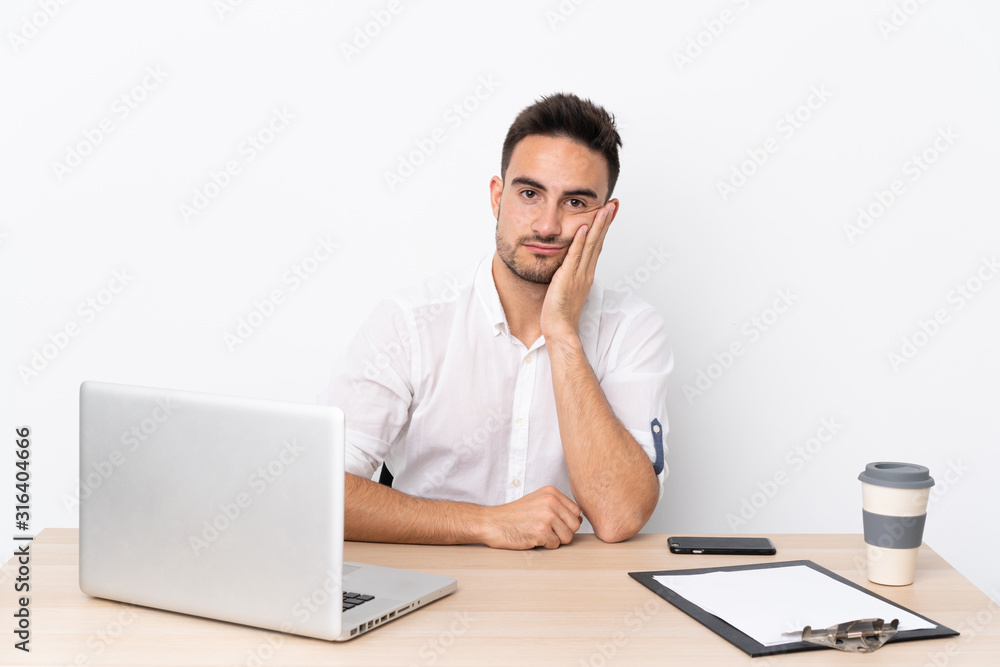 Young business man with a mobile phone in a workplace unhappy and frustrated Young business man with a mobile phone in a workplace unhappy and frustrated