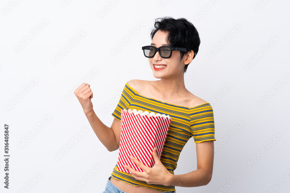 Young Asian girl with 3d glasses and holding a big bucket of popcorns while looking side Young Asian girl with 3d glasses and holding a big bucket of popcorns while looking side