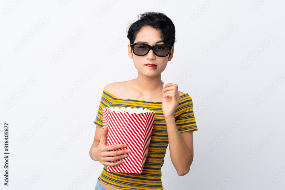 Young Asian girl with 3d glasses and holding a big bucket of popcorns Young Asian girl with 3d glasses and holding a big bucket of popcorns