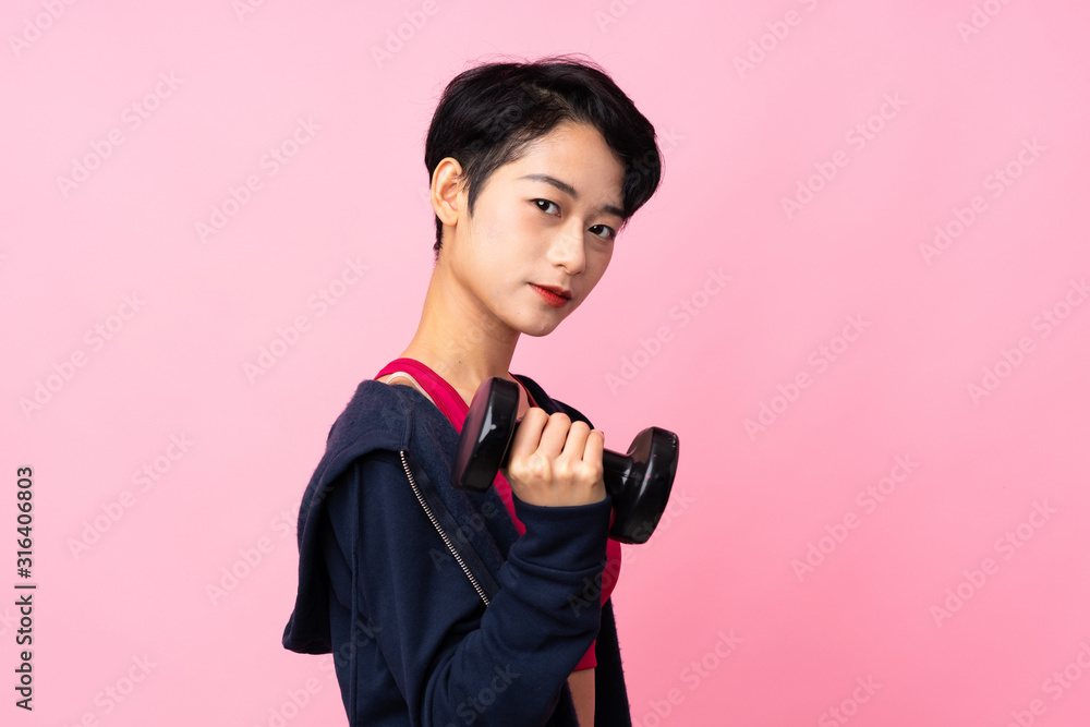 Young sport Asian woman over isolated pink background making weightlifting Young sport Asian woman over isolated pink background making weightlifting