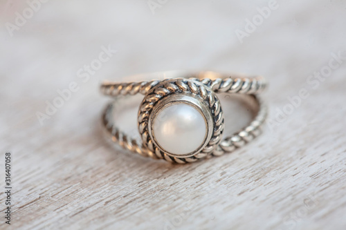 Silver ring on neutral bright wooden background