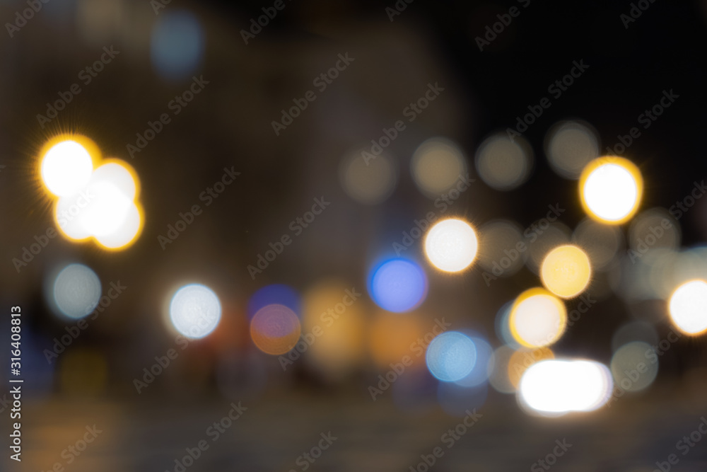 A crowd of people moving on the old european city night street defocused blurred abstract image A crowd of people moving on the old european city night street defocused blurred abstract image