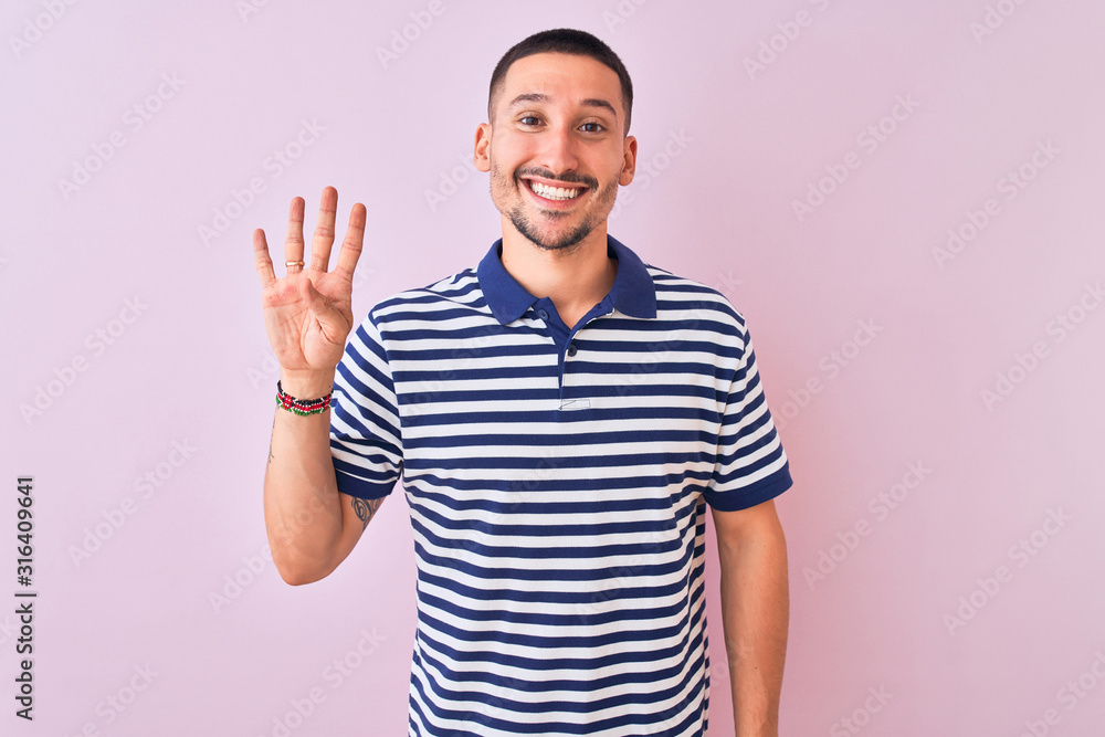 Young handsome man wearing nautical striped t-shirt over pink isolated background showing and pointing up with fingers number four while smiling confident and happy. Young handsome man wearing nautical striped t-shirt over pink isolated background showing and pointing up with fingers number four while smiling confident and happy.