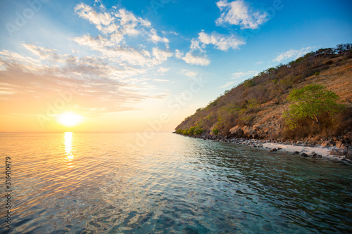 Colorful ocean sunset view with an island in the background