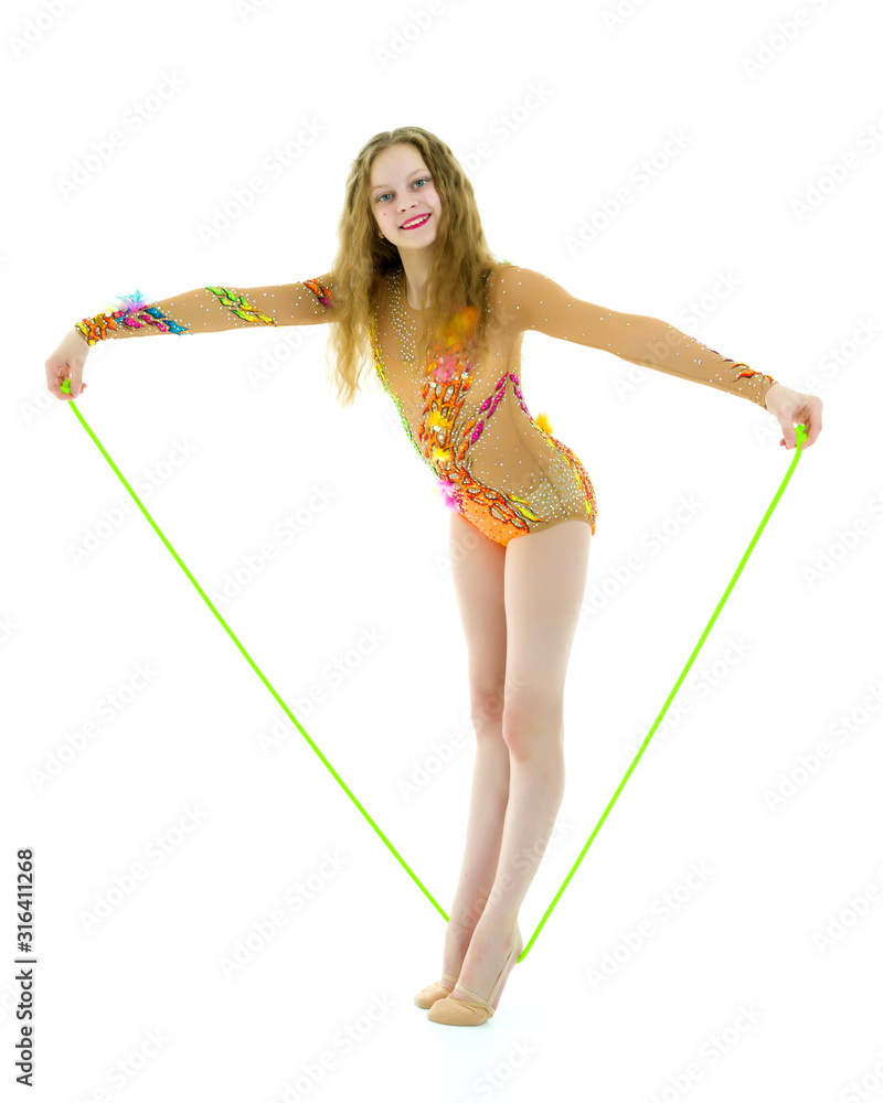 A girl gymnast performs exercises with a skipping rope. A girl gymnast performs exercises with a skipping rope.