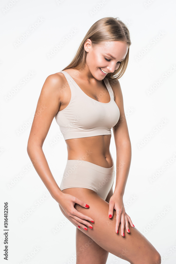 Obraz premium Health and beauty concept . Young beautiful naked woman touching her legs isolated on white background