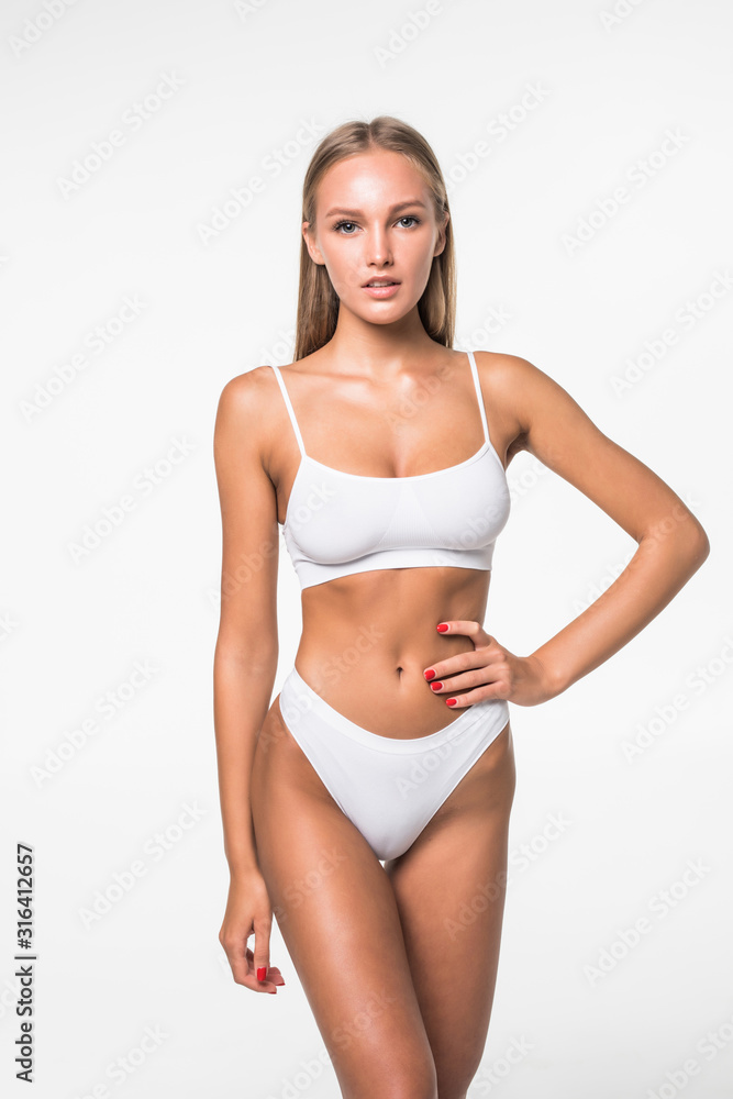 Muscular woman's body in white lingerie isolated on white background Muscular woman's body in white lingerie isolated on white background