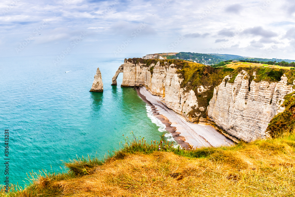 Panorama of natural chalk cliffs of Etretat with visible arche and beach coastline, Normandy, France, Europe