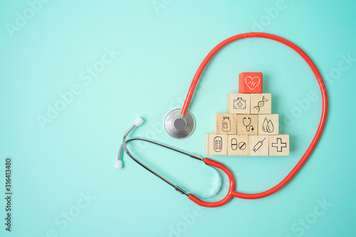 Healthcare and medical insurance concept with wooden blocks and medical icons on blue background