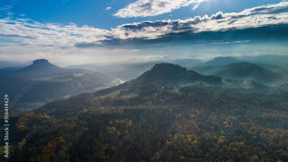 Konigstein Fortress - a Saxon mountain fortress near the town of Konigstein, located on a plateau rising  247 meters above the Elbe level, bathed in fog, aerial view