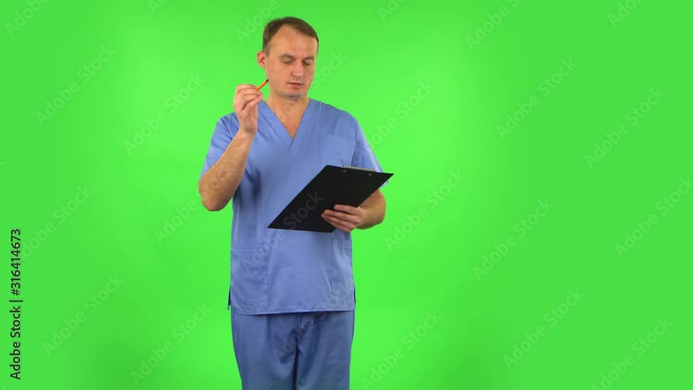 Medical man thinks, speaks and writes at black folder with pensil. Green screen Medical man thinks, speaks and writes at black folder with pensil. Green screen