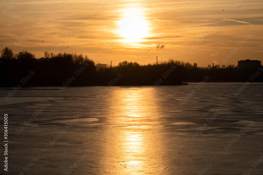 Winter sunset on the background of a frozen pond, lake. Moscow. Russia. Winter sunset on the background of a frozen pond, lake. Moscow. Russia.