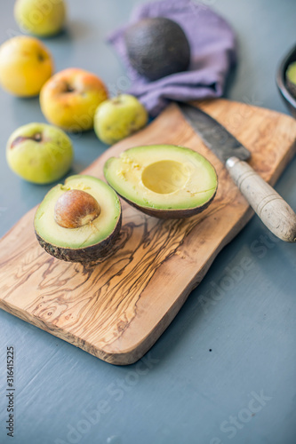 avocado on a wooden cutting board cut in half