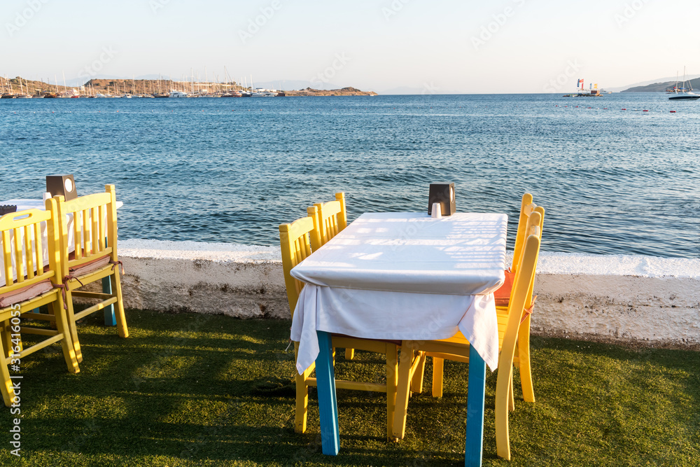 Tables in Bodrum town near beautiful Aegean Sea. Beach cafe near  sea, Turkey.  Sunset.