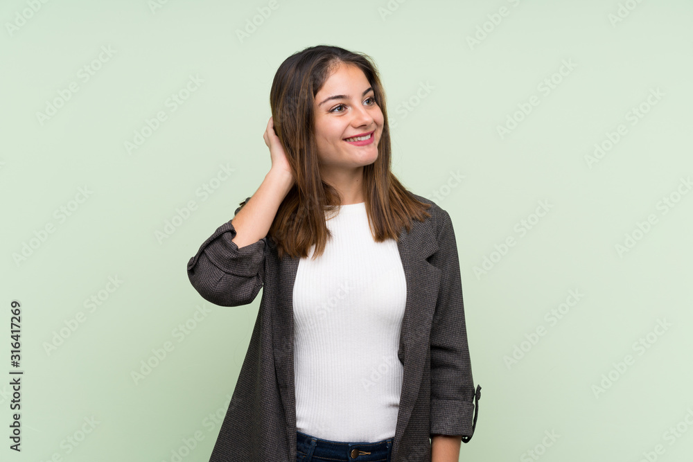 Young brunette girl with blazer over isolated green background thinking an idea Young brunette girl with blazer over isolated green background thinking an idea
