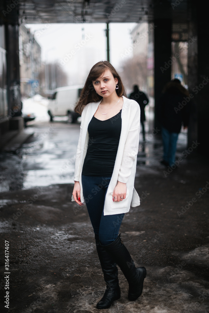 Girl in winter in a cardigan on a street in the city Girl in winter in a cardigan on a street in the city