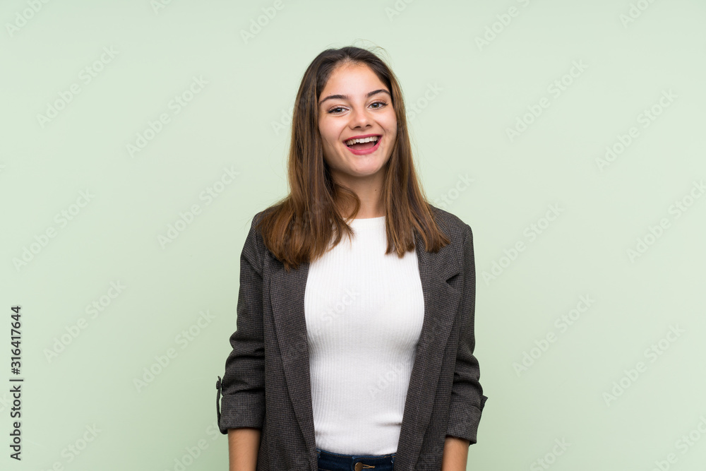 Young brunette girl with blazer over isolated green background with surprise facial expression Young brunette girl with blazer over isolated green background with surprise facial expression